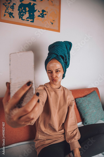 Cute female with face mask use a smartphone and enjoying at home.