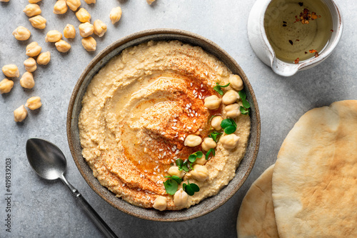 Tableau sur toile hummus in a ceramic bowl on a light background, top view