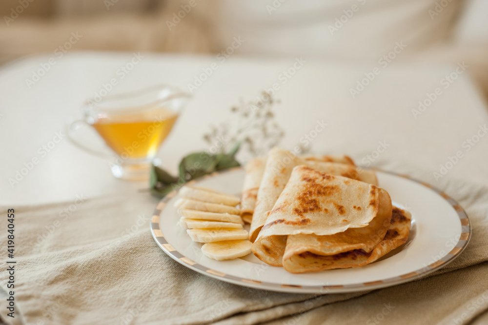 Pancakes with bananas and honey on white plate. Healthy breakfast food. Pancakes with bananas and honey on white plate. Healthy breakfast food.