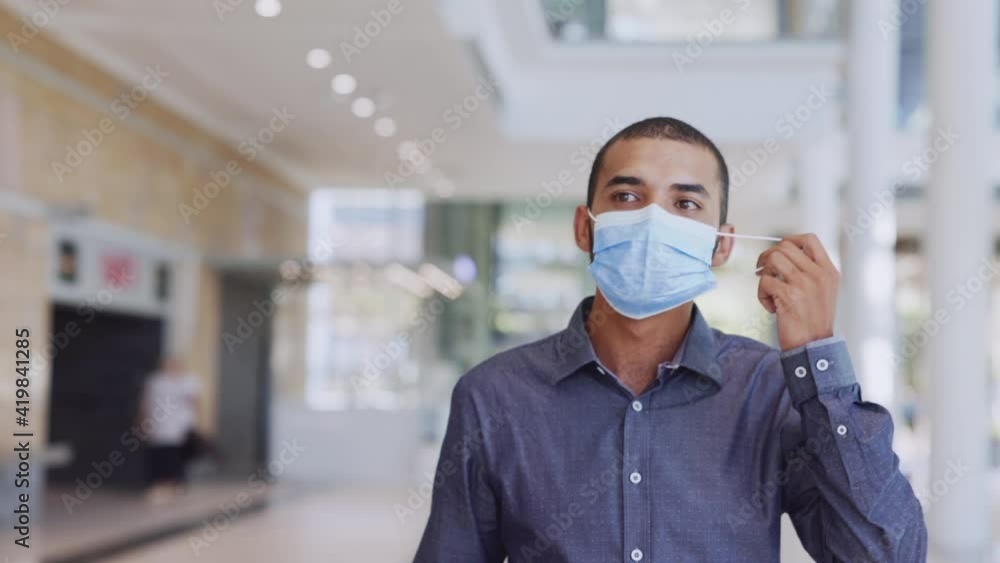 Satisfied immunized man removing his face mask after vaccination Satisfied immunized man removing his face mask after vaccination