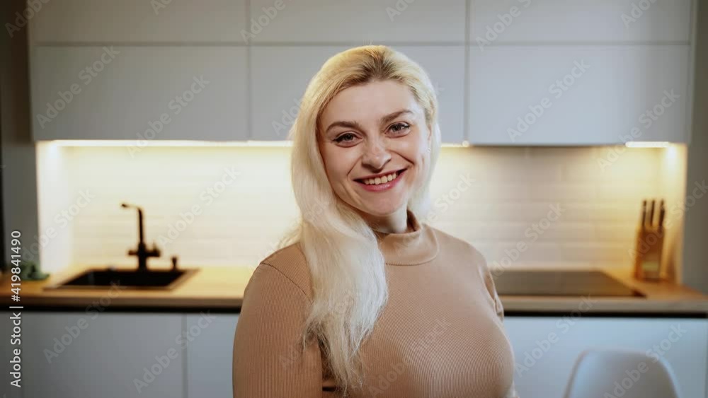 Smiling attractive young adult woman model looking at camera, happy beautiful blonde lady professional pretty face dental smile posing stand alone indoors, close up view portrait Smiling attractive young adult woman model looking at camera, happy beautiful blonde lady professional pretty face dental smile posing stand alone indoors, close up view portrait