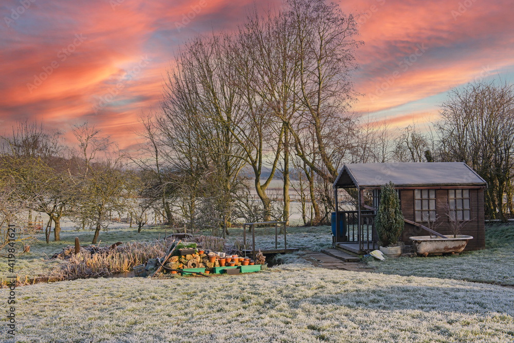 Landscape view across large garden in winter with shed