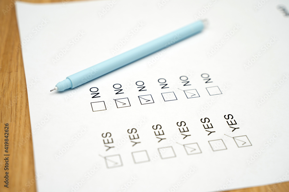 A survey form with yes or no answer options. Questionnaire on white paper, checkboxes ticked A survey form with yes or no answer options. Questionnaire on white paper, checkboxes ticked
