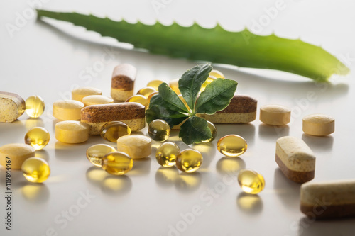 A group of food additives diffrent shape and colors with green leaf on  white background. As a concept of natural medicines. Preventive medicine. Prevention of coronovirus.