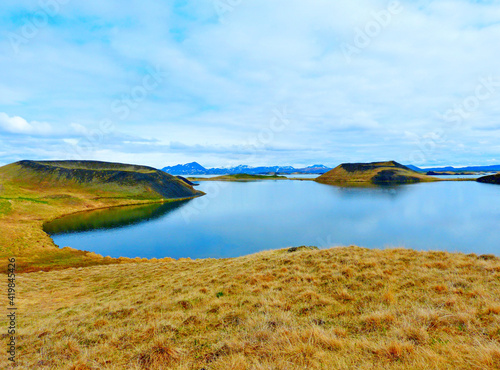 Iceland amazing lake Myvatn, incredible heaven clouds, sun, Icelandic summer, wonderful landscape, volcanic mountains, green grass moss hills. Zen, meditation, tranquility.