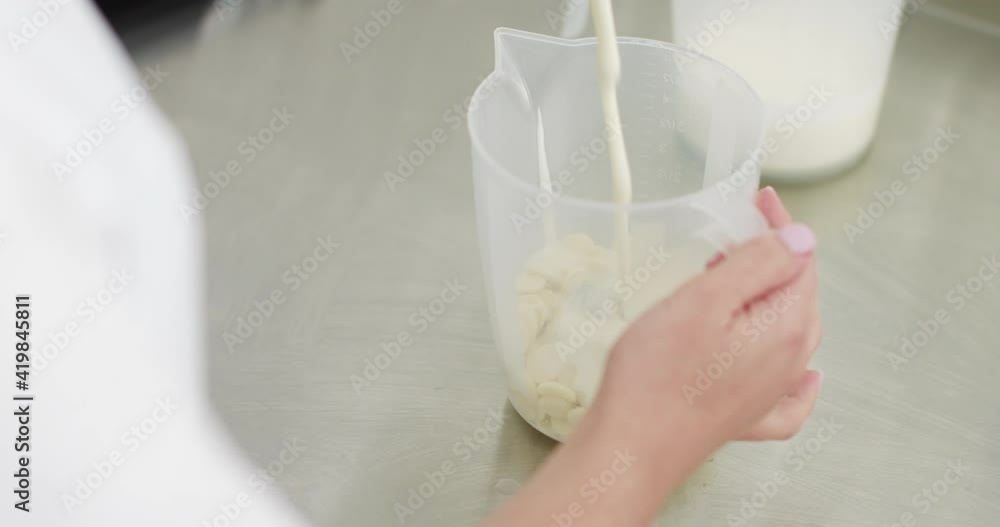 Preparation of Cream for Macarons. Chef Mixes White Chocolate With Cream or Milk. Preparation of Sauce for Desserts. Confectionery shop, baking concept. Preparation of Cream for Macarons. Chef Mixes White Chocolate With Cream or Milk. Preparation of Sauce for Desserts. Confectionery shop, baking concept.