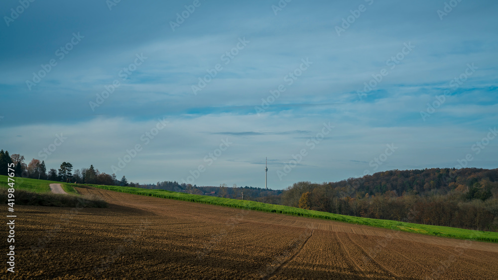 Germany, Stuttgart, Rural nature landscape of brown fields and forest surrounding tv tower Fernsehturm in autumn