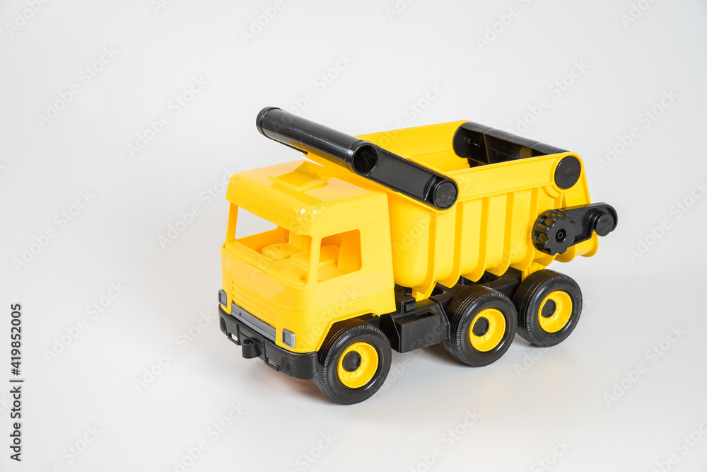 Plastic car. Toy model isolated on a white background. Yellow truck.
