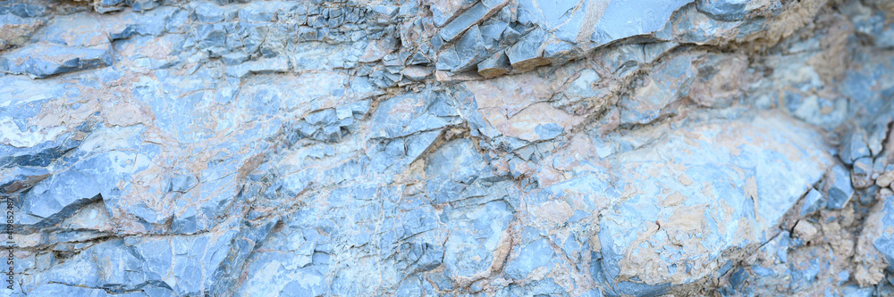 the texture of the surface of the gray blue natural stone rocks as a background. banner the texture of the surface of the gray blue natural stone rocks as a background. banner