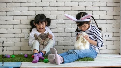 Cute happy little child girs playing with Rabbit on Easter day . photo