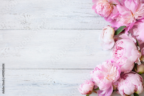 Fototapeta Naklejka Na Ścianę i Meble -  Pink peonies on a white wooden background, space for text, congratulations.