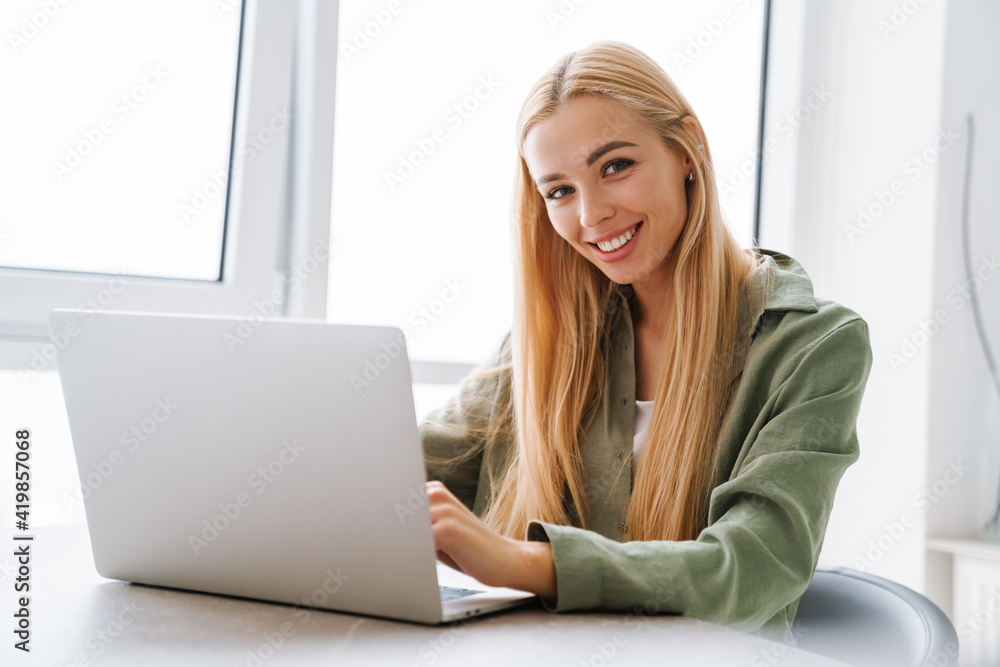 Happy attractive young blonde woman sitting at the table Happy attractive young blonde woman sitting at the table