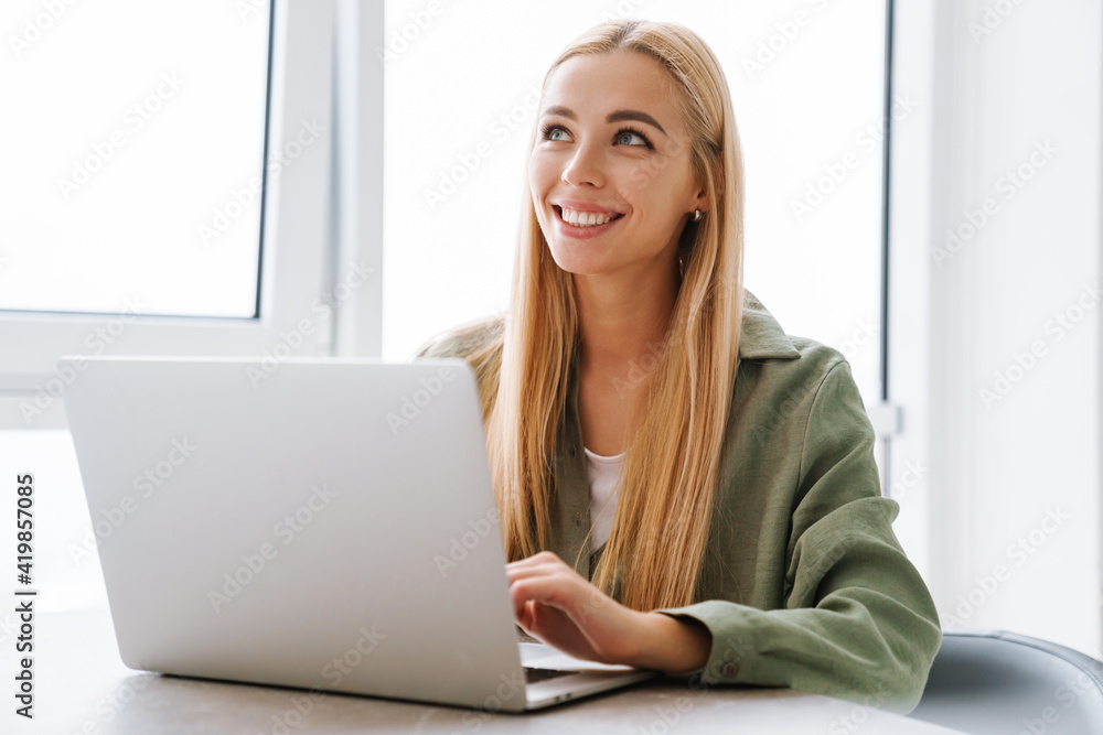 Happy attractive young blonde woman sitting at the table Happy attractive young blonde woman sitting at the table