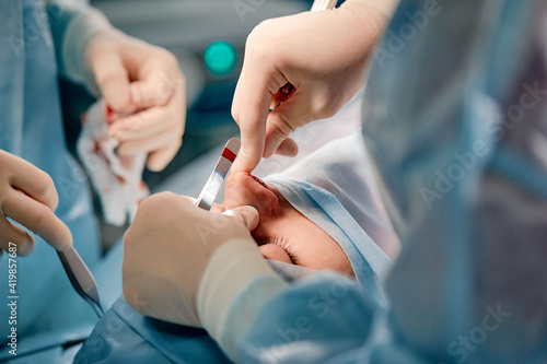 Rhinoplasty men  the surgeon s gloved hands hold the instruments during nose surgery. Doctor in gloves holds a medical instrument during rhinoplasty