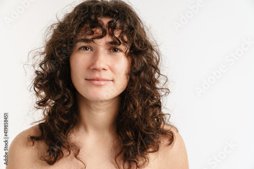 Half-naked curly woman posing and looking at camera