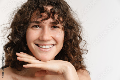 Half-naked curly woman smiling and looking at camera