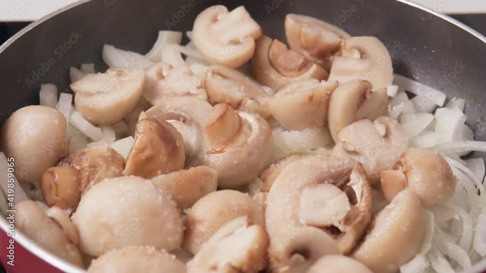 Fried Agaricus champignon mushrooms with onions and spices. Selective focus. Cooking food Fried Agaricus champignon mushrooms with onions and spices. Selective focus. Cooking food