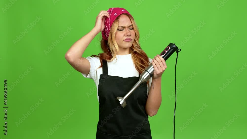 Young blonde girl using hand blender having doubts while scratching head over isolated background over isolated background on green screen chroma key background Young blonde girl using hand blender having doubts while scratching head over isolated background over isolated background on green screen chroma key background
