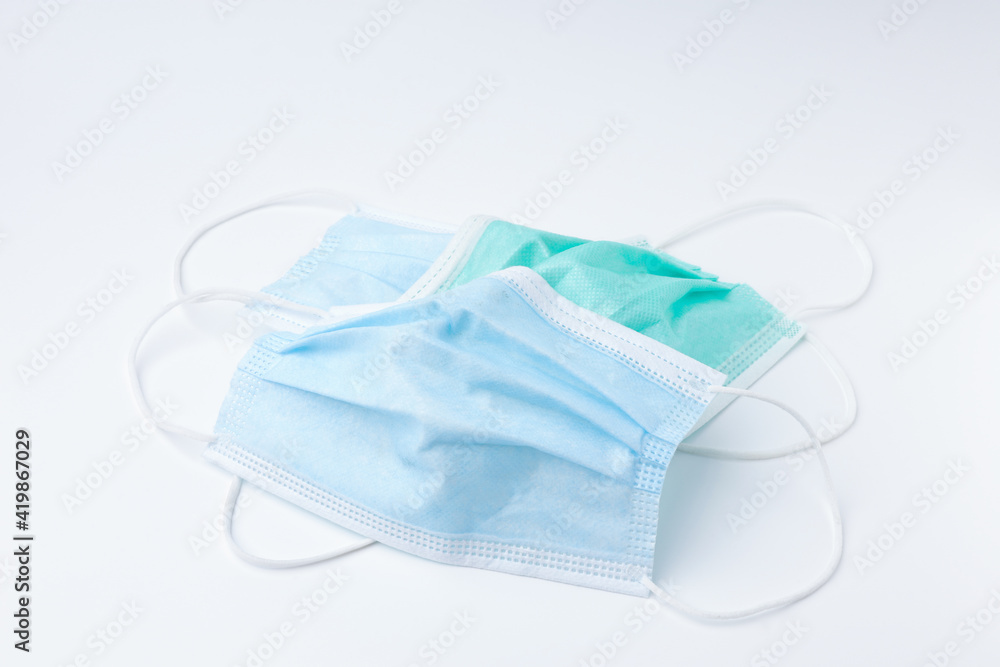 Disposable surgical face mask dirty with copy space. Mask protective coronavirus isolated on white background. Healthcare medical hygiene concept. Disposable surgical face mask dirty with copy space. Mask protective coronavirus isolated on white background. Healthcare medical hygiene concept.