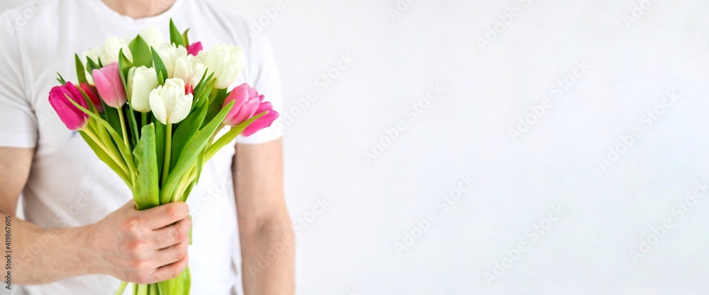 Man holding beautiful bouquet of colorful tulips. Fresh spring flowers. Valentine's Day, Women's Day, Mother's Day. Wedding concept. Spring cards. Copy space