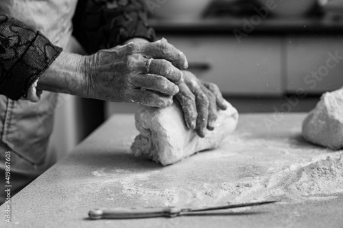 Fotografía Close up photo of old baker's hands kneading dough for bread