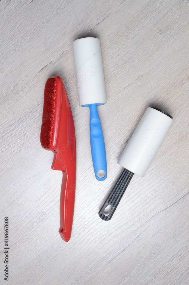 Naklejka premium brushes for cleaning clothes. sticky and a bristled brush, lie on a light-colored countertop.