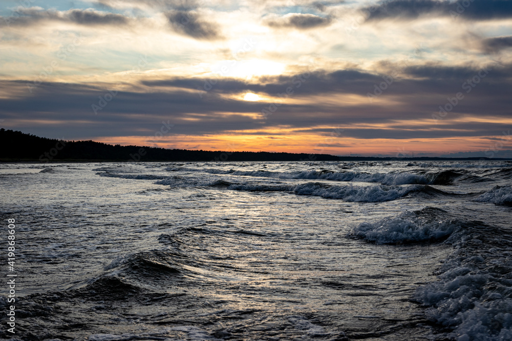 Obraz premium Beautiful cloudscape over the sea, sunset shot. beautiful shot of the sea under the orange sky and clouds at dawn or dusk in Latvia in a beautiful weather. Sunset on the horizon as a background.
