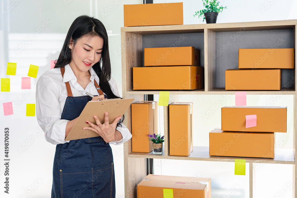 Starting a Small Business SME Owner Female Entrepreneur Reading and writing order numbers Receiving and reviewing online orders to prepare to pack boxes, sell to customers, sme business ideas online. Starting a Small Business SME Owner Female Entrepreneur Reading and writing order numbers Receiving and reviewing online orders to prepare to pack boxes, sell to customers, sme business ideas online.