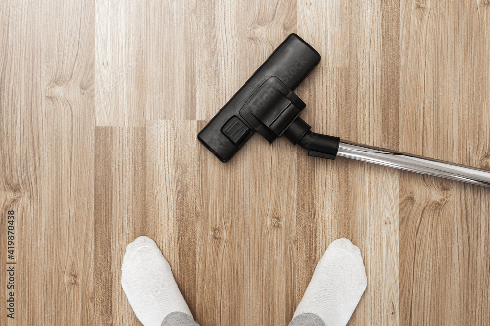 A man in white socks near a vacuum cleaner top view