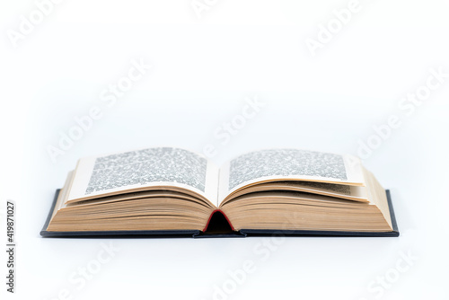 Open book isolated on white background, clipping path included. Library book with dark hard cover open on white table