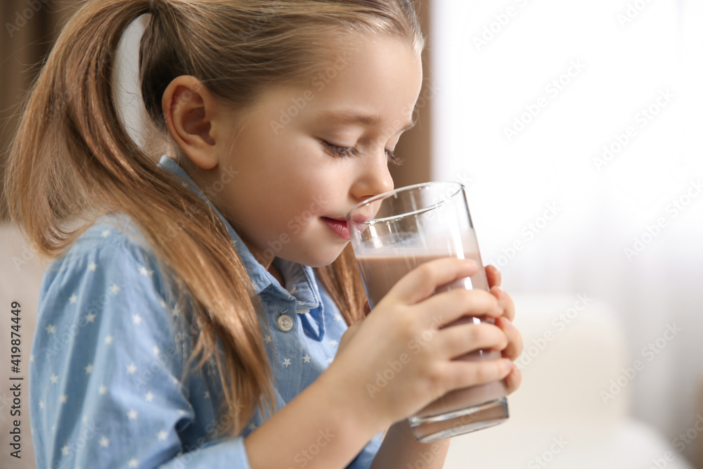Cute little child drinking tasty chocolate milk indoors, closeup. Space for text Cute little child drinking tasty chocolate milk indoors, closeup. Space for text