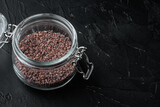 Indian Black salt, Kala namak hindi Healthy food concept, in glass jar, on black stone background , with copyspace  and space for text