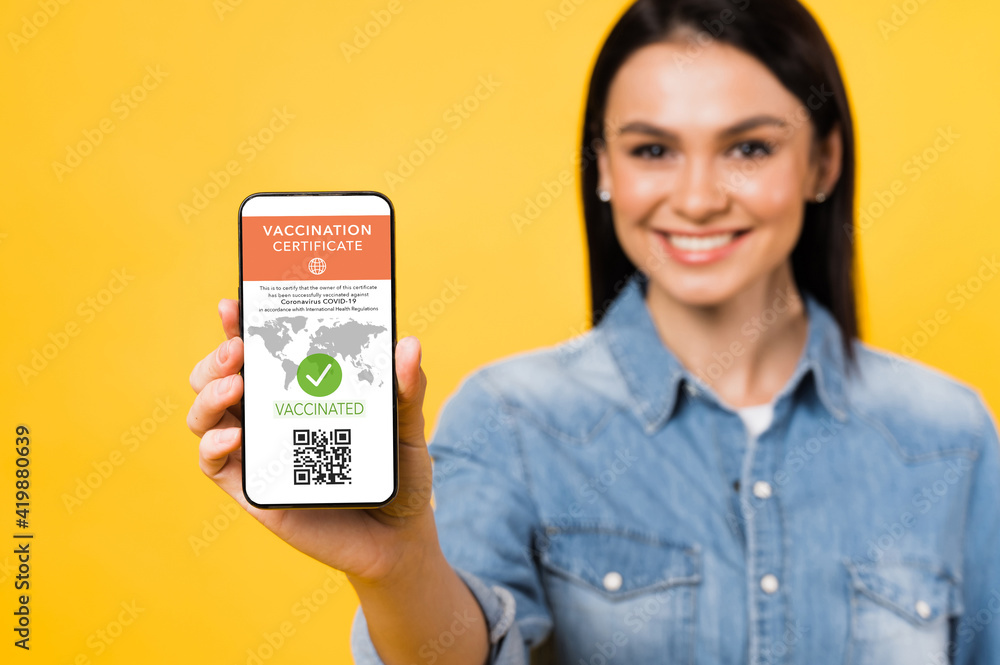 Defocused Woman Holds Smartphone Displaying Valid Digital Vaccination Defocused woman holds smartphone displaying valid digital vaccination