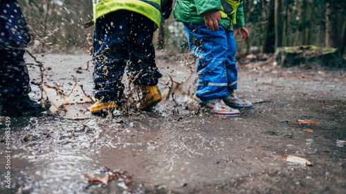 lower section of children playing in puddle