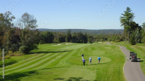 Golfers teeing off on a beautiful summer day with clear skies photo