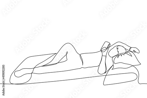 man lies holding a phone in his hands, his other hand is resting on the pillow, his leg is bent at the knee - one line drawing. the concept of mobile online surfing lying in bed before going to bed