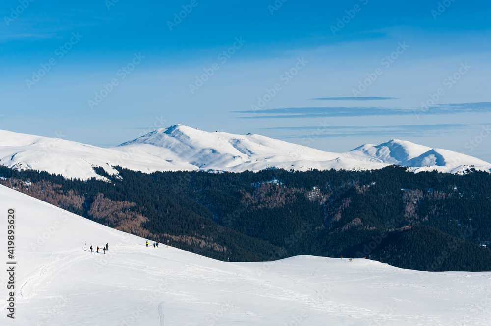 Group of hikers in snowy mountain landscape in Romanian Carpathians