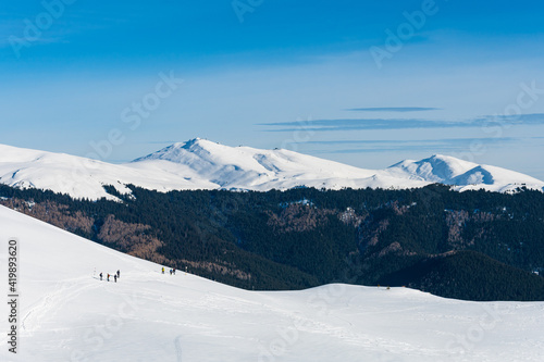 Group of hikers in snowy mountain landscape in Romanian Carpathians