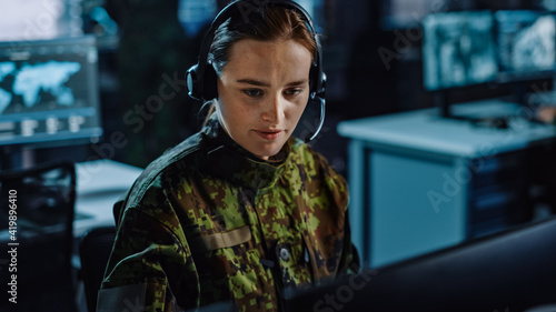 Beautiful Female Military Surveillance Officer in Headset Working in Central Office Hub for Cyber Operations, Control and Monitoring for Managing National Security, Technology and Army Communications.