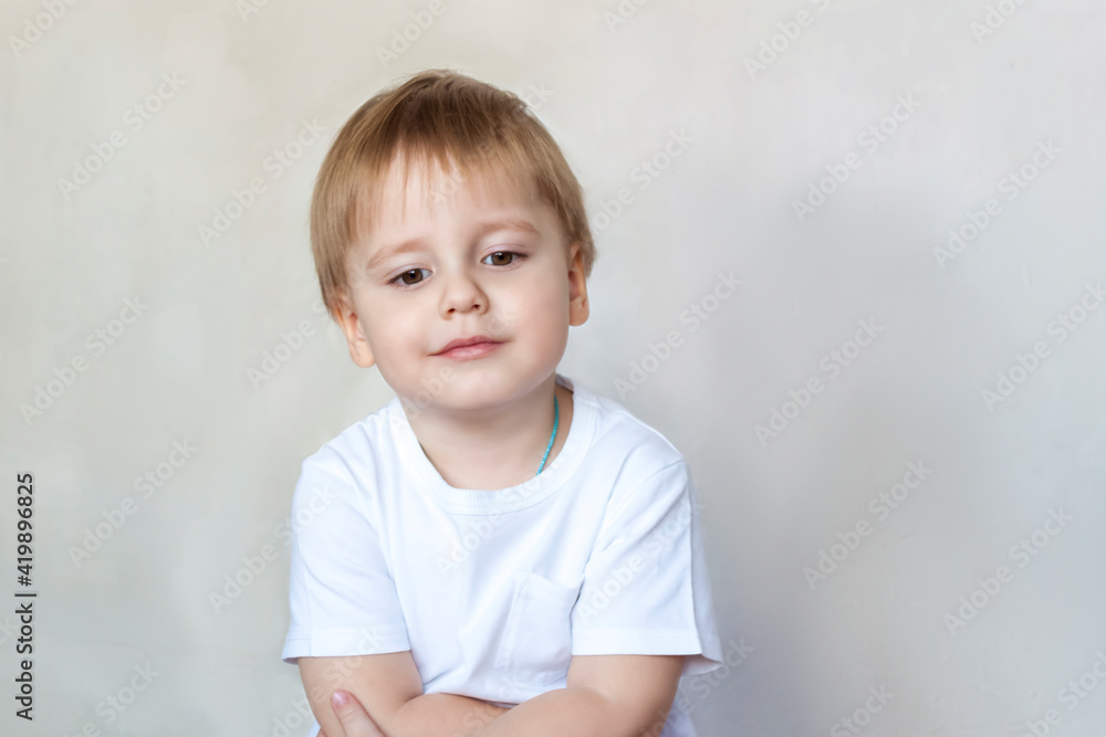Portrait of a cute little boy in a white t-shirt. Children's emotions. Child on the background of the wall. Success, bright idea, creative ideas and concepts. Portrait of a cute little boy in a white t-shirt. Children's emotions. Child on the background of the wall. Success, bright idea, creative ideas and concepts.