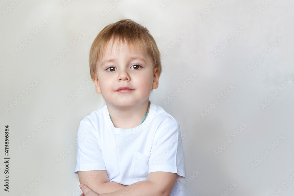 Portrait of a cute little boy in a white t-shirt. Children's emotions. Child on the background of the wall. Success, bright idea, creative ideas and concepts. Portrait of a cute little boy in a white t-shirt. Children's emotions. Child on the background of the wall. Success, bright idea, creative ideas and concepts.