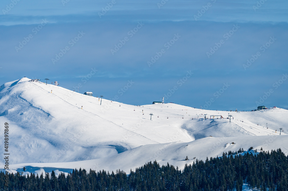Alpine ski lift on top of snow covered Romanian Carpathian mountains during winter