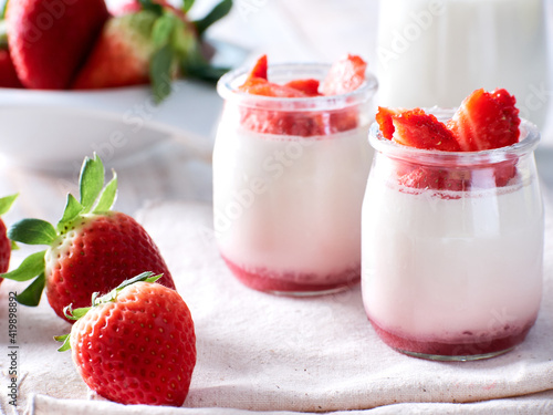 two glasses of yogurt and fresh strawberries  close up look