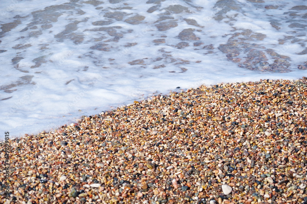 wave covers pebble beach on a summer day wave covers pebble beach on a summer day