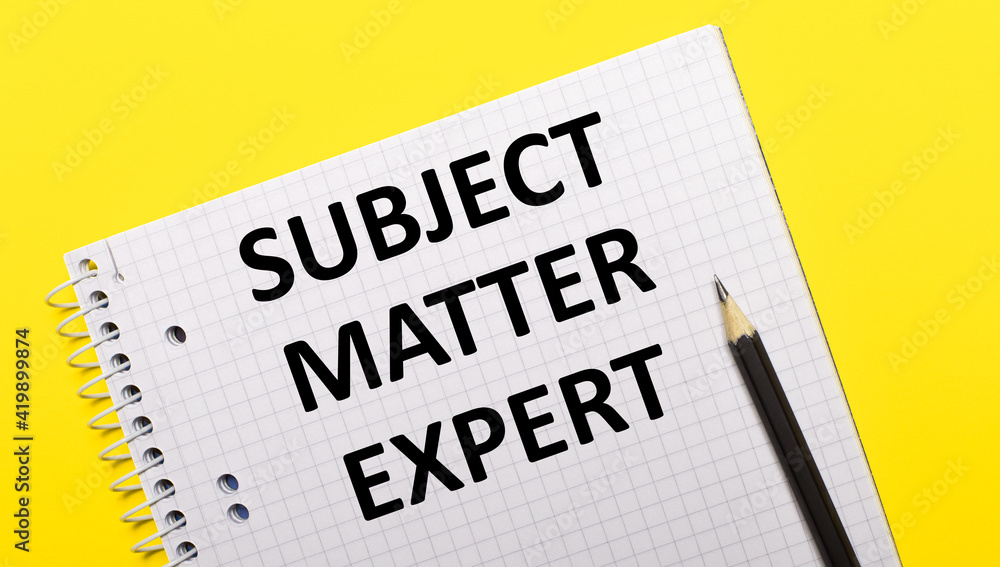 White notebook with inscription SUBJECT MATTER EXPERT written in black pencil on a bright yellow background.