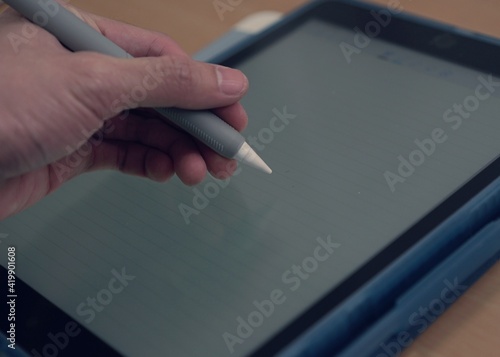 hand with pen​ stylus on tablet