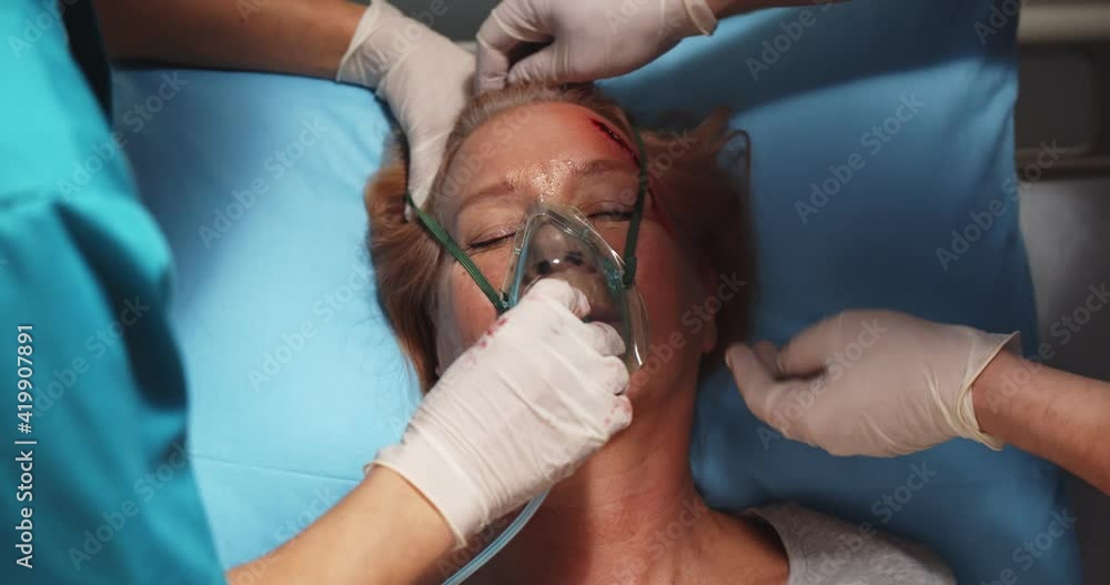 Close up of doctor putting mask on unconscious woman patient Close up of doctor putting mask on unconscious woman patient