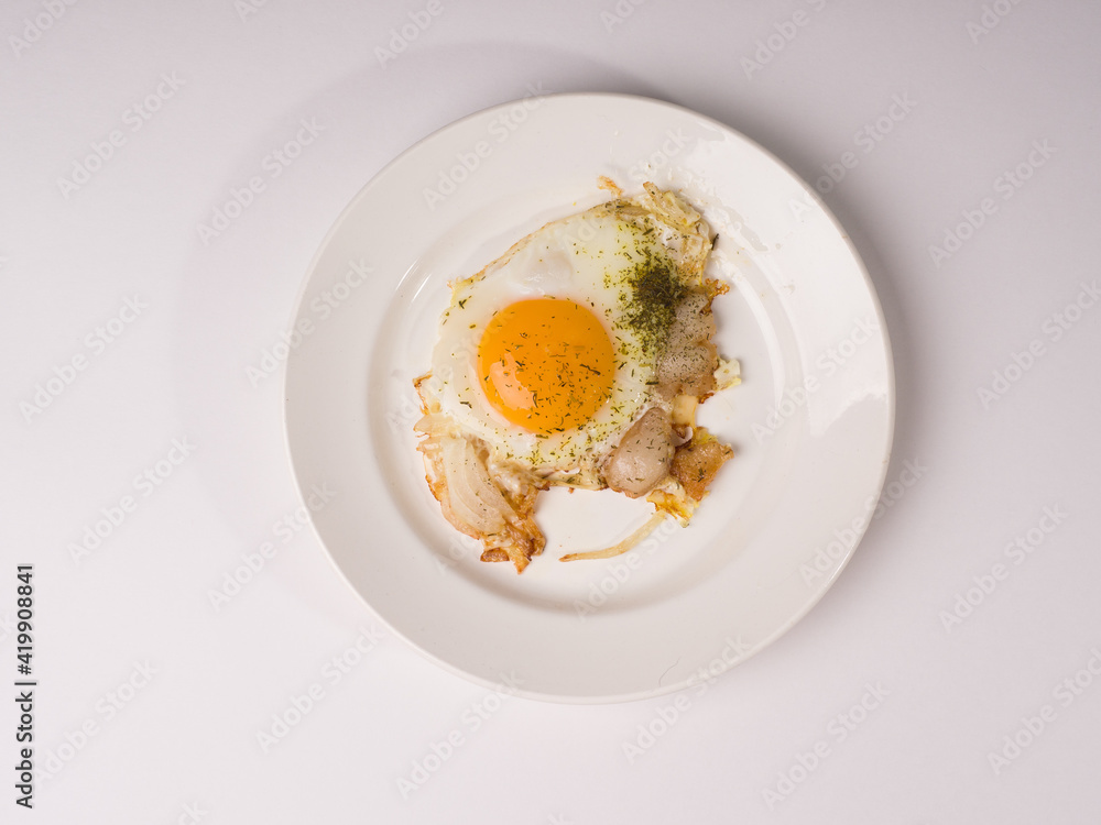Fried eggs on a white round plate. Studio photo on white background Fried eggs on a white round plate. Studio photo on white background