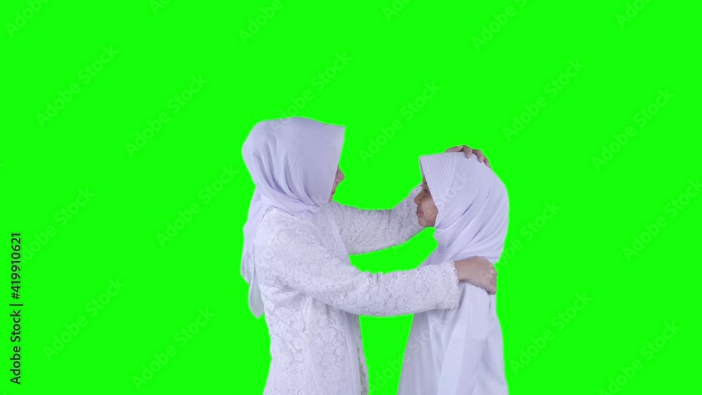 Young mother tidying veil of his daughter on studio Young mother tidying veil of his daughter on studio