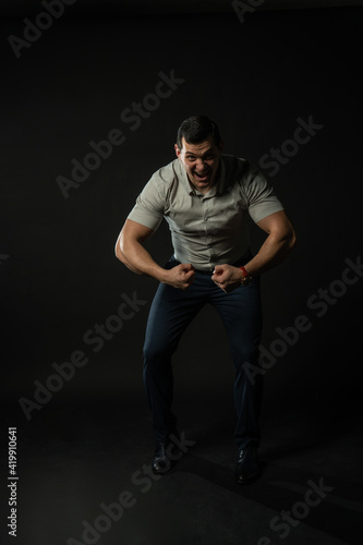 Squeezes his hands at the bottom of the happy swing in a working shirt confident caucasian, attractive happy, happiness beautiful. Men formal fashionable cool black